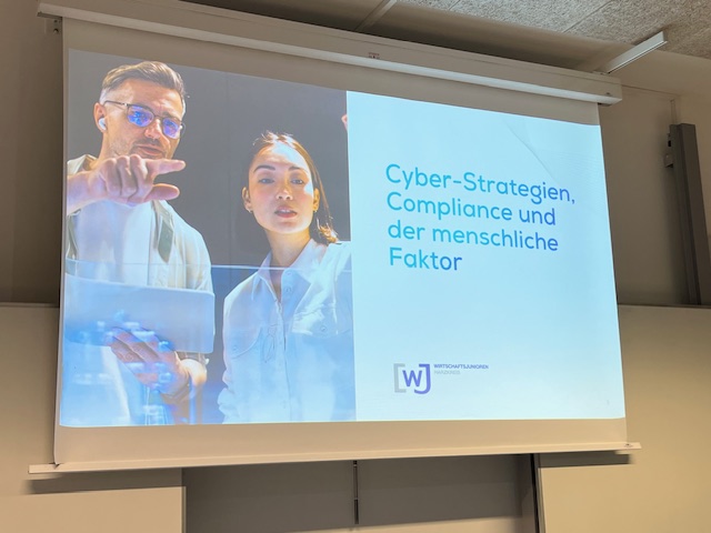 Projektion mit Titel "Cyber-Strategien Compliance und der mescnhlcihe Faktor"