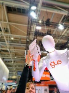 Frau streckt ihre Hand nach oben zu einer Hand eines Roboters