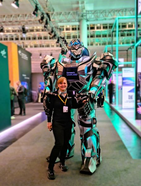 Megatron steht neben Frau und ist 1,5 mal so groß